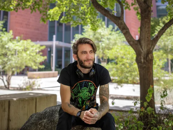 Young man with beard in black shirt outdoors
