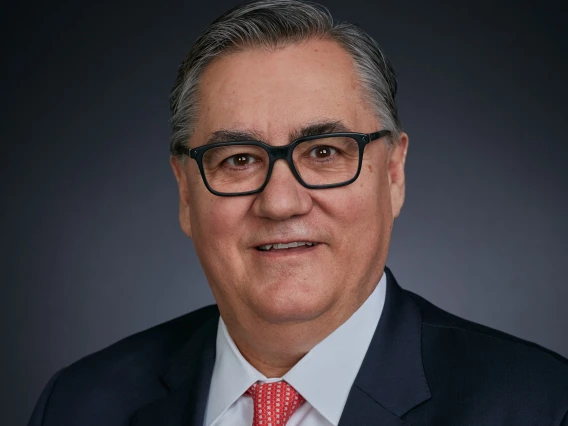 Photo of Tomás Díaz de la Rubia smiling, wearing a dark suit jacket and light red tie