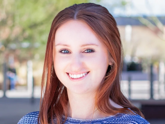 College student with auburn hair and blue striped sweather