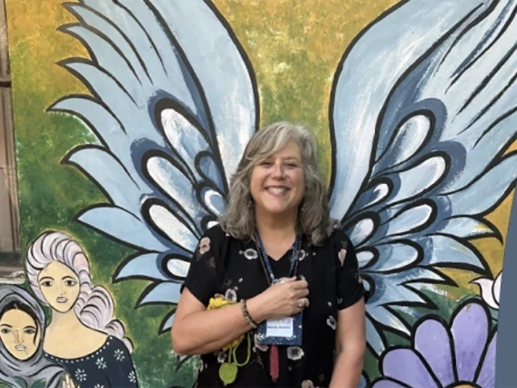 WOMAN IN FRONT OF wings mural