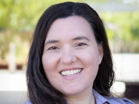 long, brown-haired smiling woman in lavendar button-down