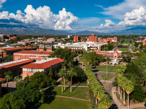 An aerial phot of the University of Arizona campus with red brick buildings under a blue sky.