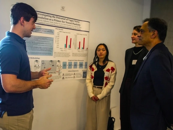 Students present their research poster to U of A President Suresh V. Garimella
