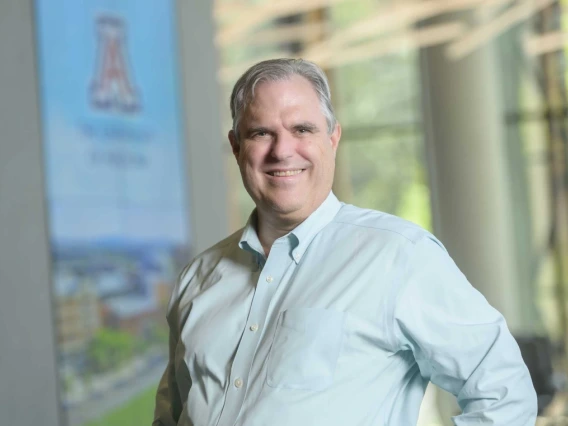 A photo of Justin Starren, smiling in a casual pose, wearing a light blue button down shirt