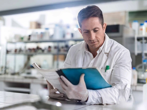 A researcher reads a pamphlet in a laboratory