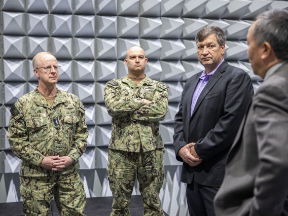 Admiral Caudle, standing in the anechoic chamber in the Applied Research Building, listens to Elliot Cheu, interim senior vice president of research and innovation.