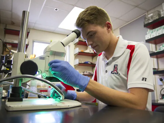 Briggs Carhart examining a sample under a microscope.