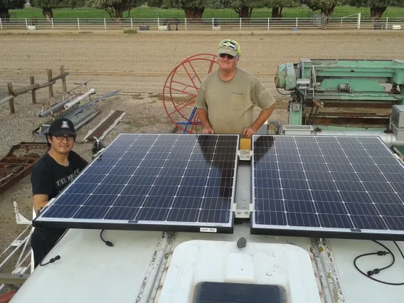 UA research associate Bob Seaman and Chris Yazzie, a master's degree student in environmental engineering, fasten solar panels to the roof of the bus that will purify water in Navajo Nation. (Photo: Rodolfo Peon)