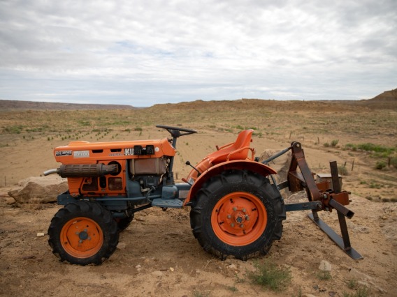 an orange tractor parked on arid land