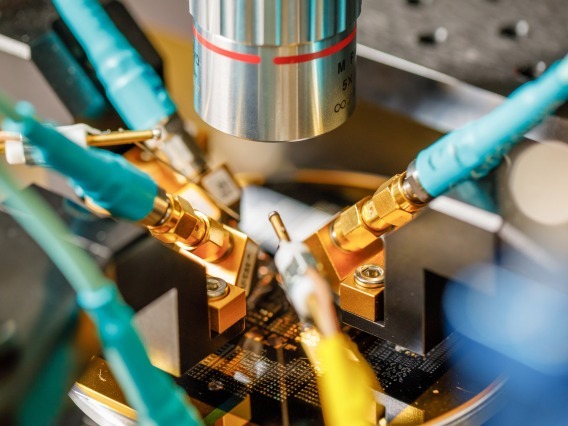 A silicon wafer with a phononic device is being tested under a microscope. 