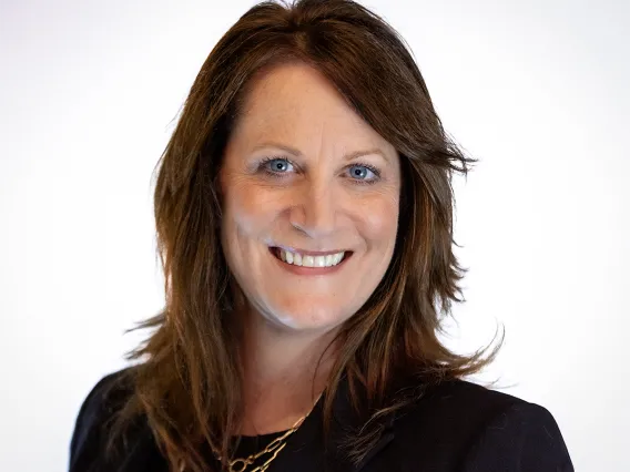 Portrait of Lisa Romero, smiling, wearing a black blazer