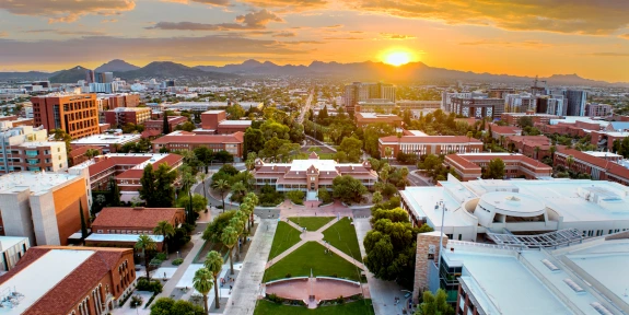 sun setting over the mountains beyond the university campus