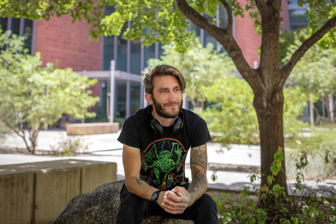 Young man with beard in black shirt outdoors