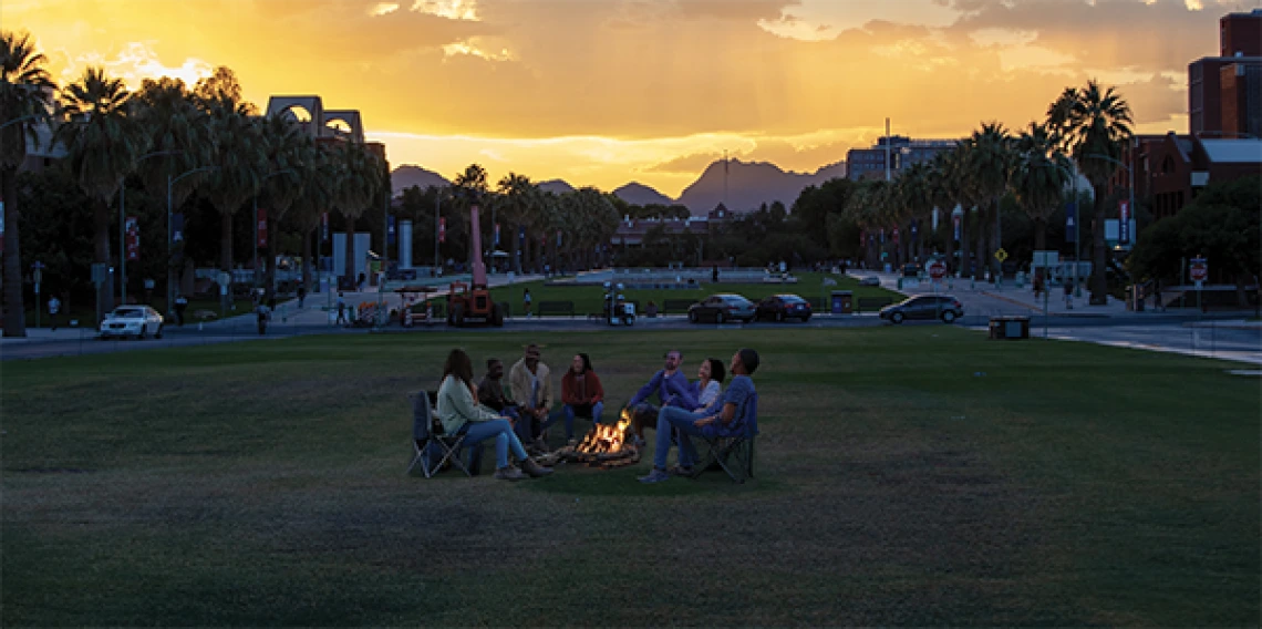 Image of group around campfire is AI generated.  