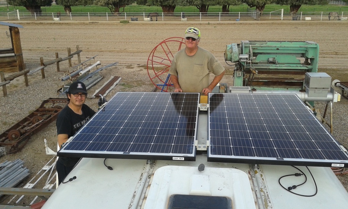 UA research associate Bob Seaman and Chris Yazzie, a master's degree student in environmental engineering, fasten solar panels to the roof of the bus that will purify water in Navajo Nation. (Photo: Rodolfo Peon)