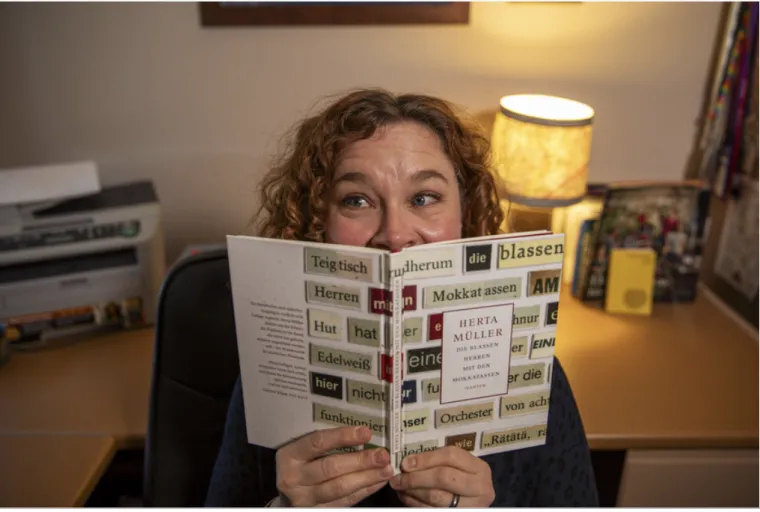 Chantelle Warner peeks out from behind a book in her office