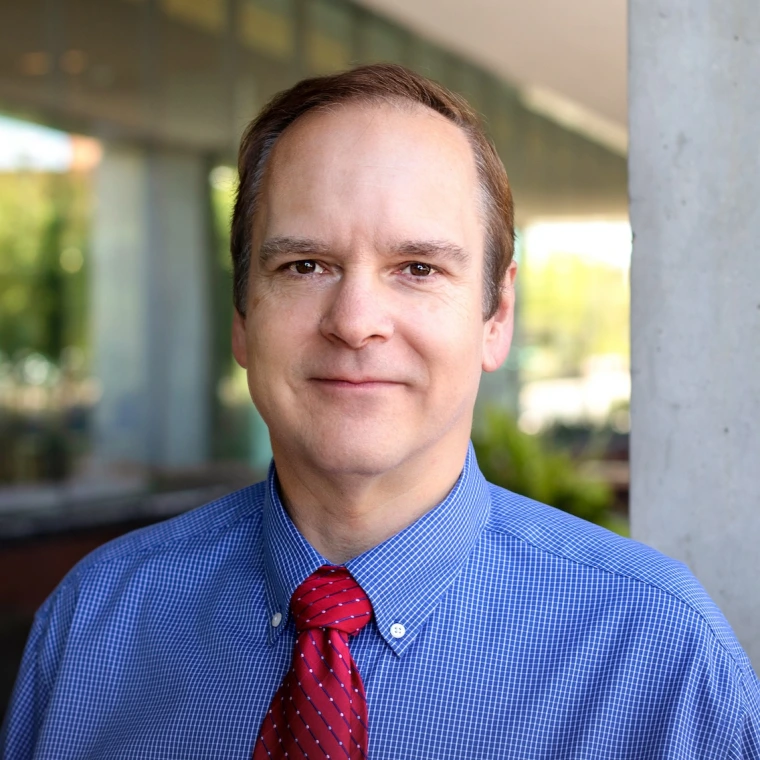 smiling man wearing a red tie and blue shirt