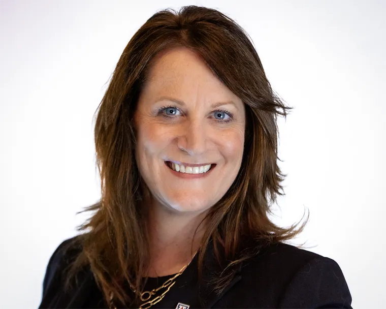 Portrait of Lisa Romero, smiling, wearing a black blazer