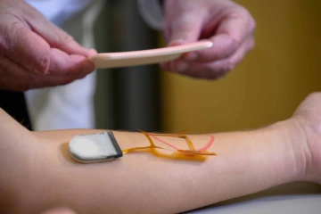 A researcher demonstrates the use of a smart bandage on a model patient