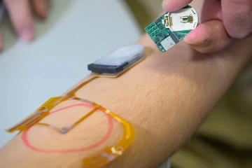 A researcher demonstrates the use of a smart bandage on a model patient