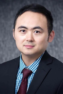 Portait of researcher Jianqin Lu wearing a suit and tie