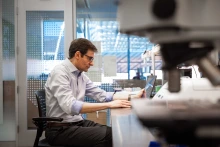 Stefano Guerra, MD, PhD, works with laptop in a University of Arizona research laboratory