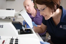 two people look at equipment in a lab