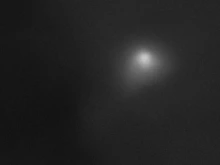Comet 3I/ATLAS is visible as a smudgy, white speck with a diffuse halo around it against jet-black background of space. 