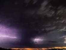 Clouds and lightning over a desert landscape