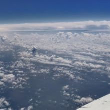 A photo of the top of the cloud layer, taken from a plane. The wing of the plane is visible