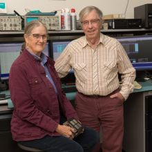 Marcia and George Rieke posing in front of computer monitors in the lab
