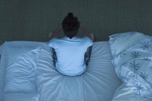 Image of person sitting on a bed