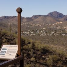 A simple pinhole camera, mounted atop a pole, looks out across a desert landscape. 