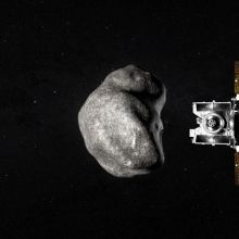 A spacecraft flies by an asteroid in the blackness of space
