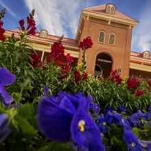 old main with flowers in front of it