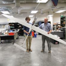 two men folding 11-foot sailplane