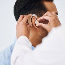 Man trying on hearing aid