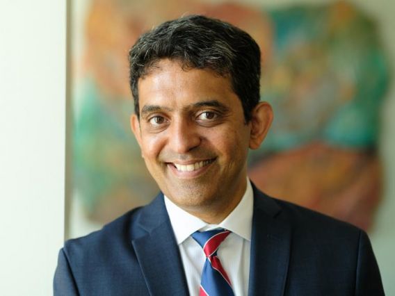 Karthik Kannan smiling, wearing a suite and tie