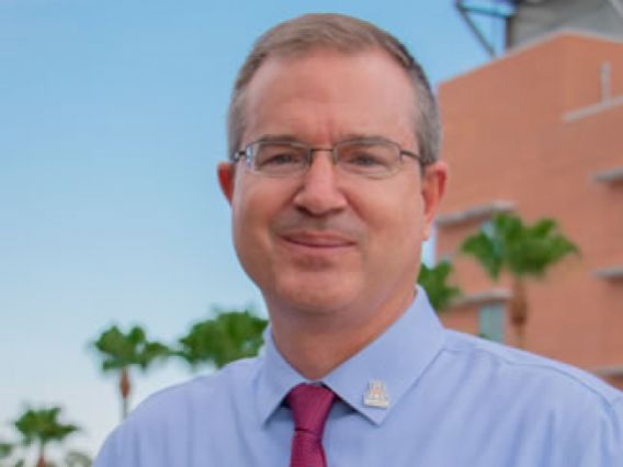 David Hahn smiling wearing a blue shirt and red tie with an Arizona logo pin on his collar