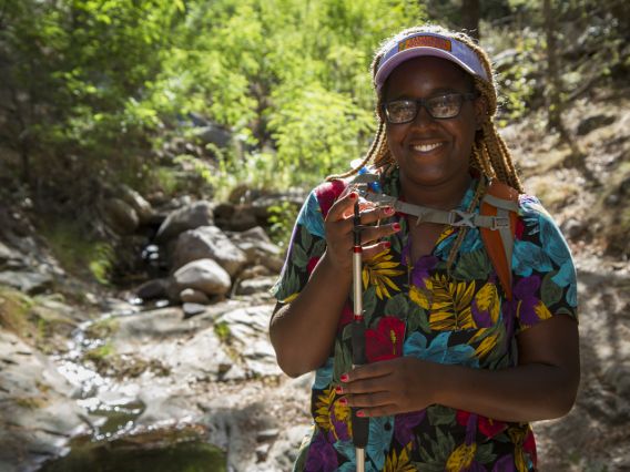 Earyn McGee holding a lizard in a dry stream bed in the Chiricahua Mountains
