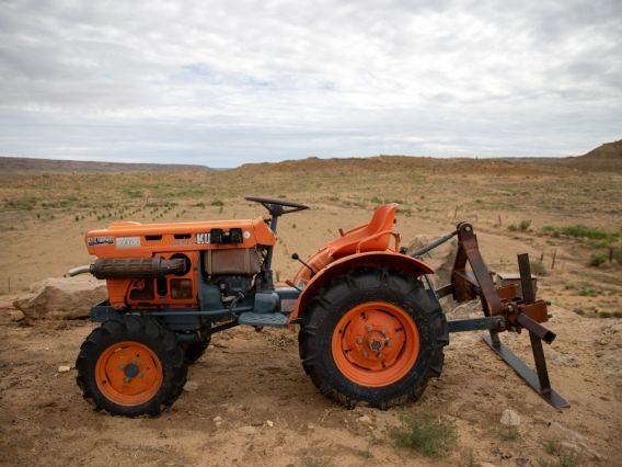 an orange tractor parked on arid land