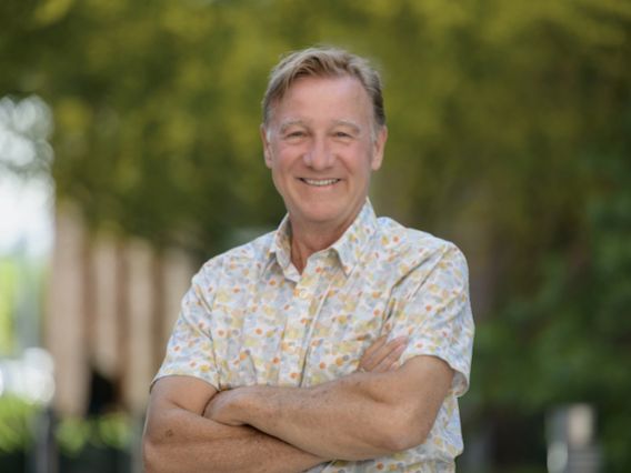 headshot photo of Jim Buizer standing outside in front of some trees