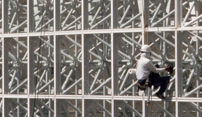 worker climbing wall of biosphere 2 structure