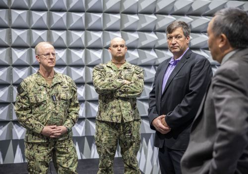 Admiral Caudle, standing in the anechoic chamber in the Applied Research Building, listens to Elliot Cheu, interim senior vice president of research and innovation.