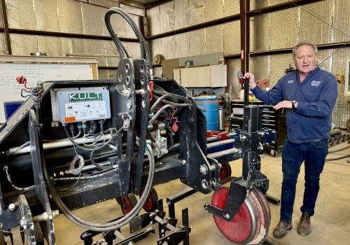 Mark Siemens, associate professor of biosystems engineering, stands beside technology he incorporates into his focus of precision and mechanized agriculture.