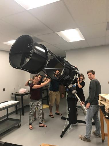 Peering through the structure of one of the telescopes they built, the students on Dr. Vishnu Reddy's Design Day telescope team include, clockwise from top left: Ryan Bronson, Sameep Arora, Lindsie Jeffires, Evelyn Hunten, and Damon Marco Colpo.