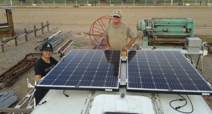 UA research associate Bob Seaman and Chris Yazzie, a master's degree student in environmental engineering, fasten solar panels to the roof of the bus that will purify water in Navajo Nation. (Photo: Rodolfo Peon)