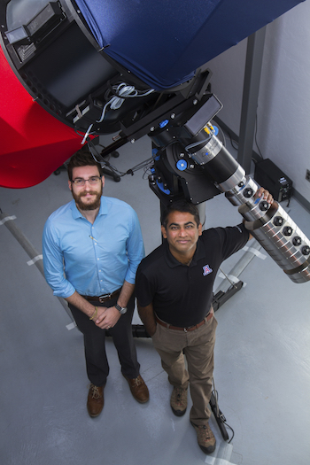 Vishnu Reddy (right) and Tanner Campbell (left) stand next to the RAPTORS telescope located at UA's Kuiper Space Sciences building. They would like to mount an optical sensor system on the telescope in the future.